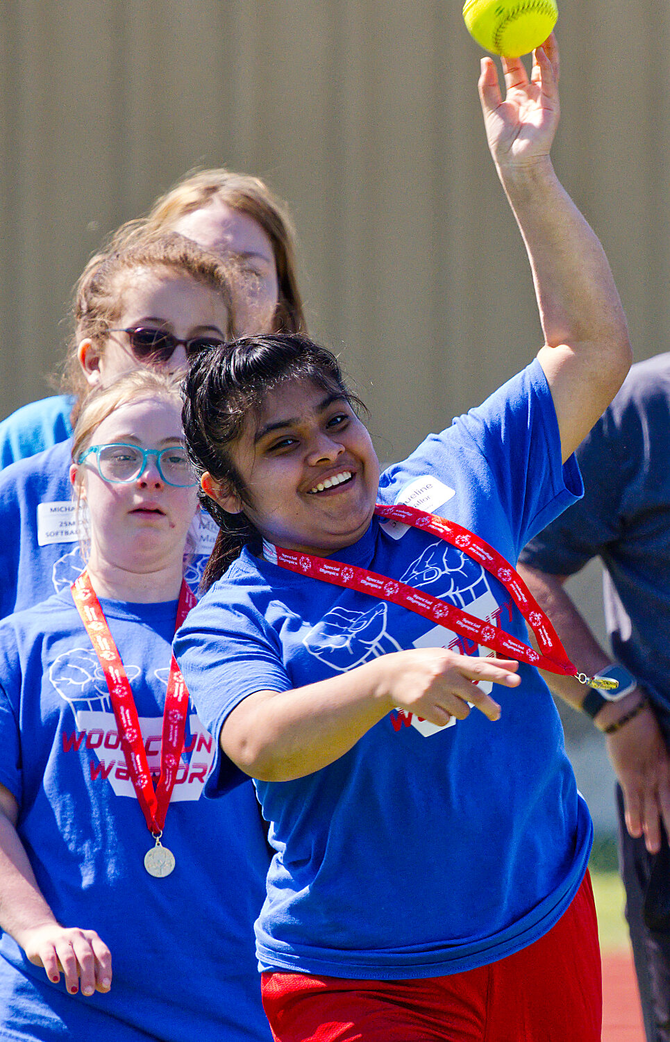 A southpaw tosses the softball skyward. [see more special olympics success]
